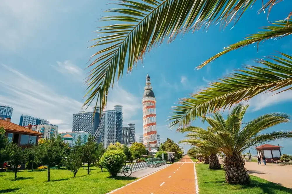 Palm fronds frame Batumi’s waterfront boulevard and distinctive tower